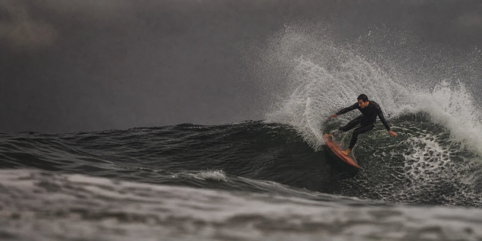 Surfista a desenhar uma curva numa onda atlântica em Portugal